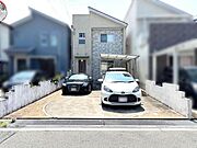 現地写真、日当たり良好な立地。駐車スペースも広く4台駐車可能、車の出し入れがしやすい設計です。角度の異なる屋根デザインが特徴的です。