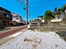 外観：前面道路に面した更地周囲に住宅が並ぶ