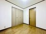 洋室：木目調の床と収納扉がある洋室