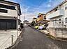 周辺：住宅街の静かな道路と駐車スペースが見える外観