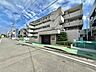 外観：コンクリート造の集合住宅外観と前面道路