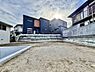 外観：建物に囲まれた土の敷地と外周の擁壁