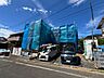 外観：青い外壁の建物と前面道路、駐車スペース