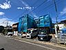 外観：青いネットで覆われた建物と前面道路