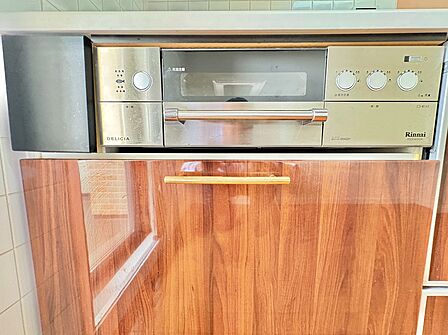 木目調の収納とコンロ周りを備えたキッチン