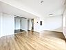 リビング/ダイニング：木目調の床が広がる明るいリビング