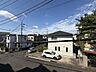 外観：建物外観と前面道路、周辺の住宅を望む景観