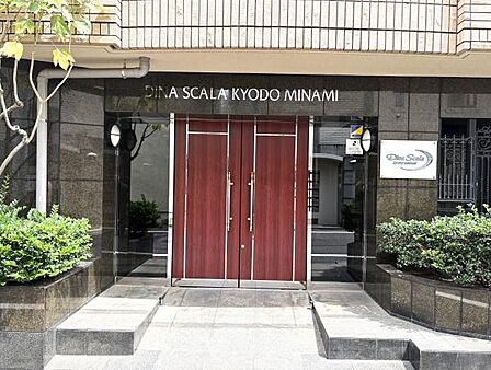 大理石貼りの高級感あるエントランス。モダンな赤色の扉が人目を引きます。