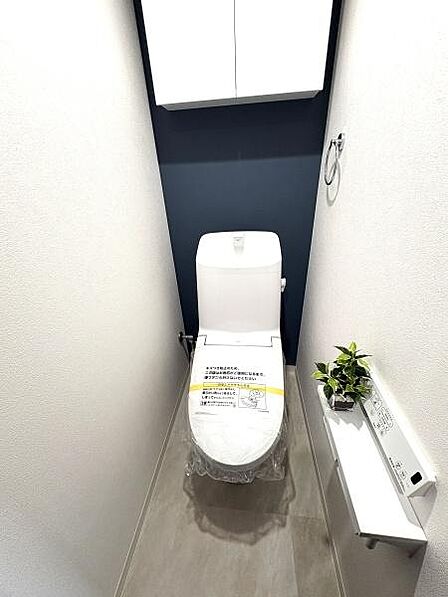 ネイビーのアクセントクロスが爽やかで清潔感あるトイレルーム。温水洗浄便座付!