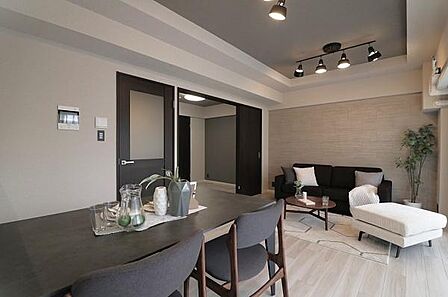 【リビング】アクセントウォールにはナチュラルな木目調クロスを採用し、間接照明とスポットライトの組み合わせが上質な陰影を演出。