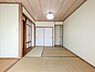 和室：落ち着いた色合いの和室が広がります。障子やふすまのデザインも特徴的です。ゆったりとした畳スペースが魅力です。天井の照明が空間を明るく照らします。収納部分も使いやすい配置です。