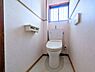 トイレ：明るい窓から自然光が差し込むトイレです。シンプルな内装で清潔感があります。ペーパーホルダーも付いていて使いやすい空間です。コンパクトなレイアウトでお手入れも簡単です。