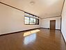 洋室：大きな窓からたっぷりと自然光が入る洋室です。木目調の床が空間に温もりを加えています。天井が高めでゆったりとした印象があります。