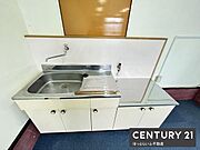 シンプルなデザインのキッチンは清潔感のあるホワイトカラーでまとまっています。使いやすいシンクと作業スペースが確保されています。収納スペースも備えているため調理器具などの整理整頓がしやすいです。