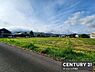 外観：広々とした現地土地写真です。周辺には建物が点在し開放感があります。青空が広がり自然を感じられる環境です。きれいに整った道路に面しています。穏やかな雰囲気のエリアです。