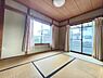 和室：大きな窓からたっぷりと自然光が差し込み明るい印象の和室です。畳の質感が部屋全体に落ち着きを与えています。障子やふすまのないシンプルな造りがすっきりとした空間を演出します。