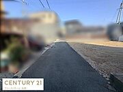 現地の前面道路は舗装されており落ち着いた雰囲気が感じられます。建物の外観や周囲の住宅も確認でき周辺の様子も一目でわかります。