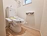 トイレ：清潔感のあるトイレ空間です。小窓があり換気もしやすく明るい印象があります。未使用状態の設備が設置されています。ペーパーホルダーも使いやすい配置です。床の色合いが空間全体を明るく見せています。