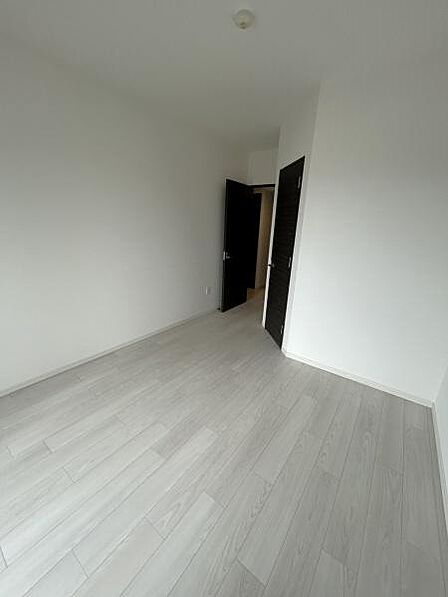 明るい木目調のフローリングとダークブラウンの建具が調和した、落ち着きのある室内です。約7帖の洋室です。ゆとりある広さで、主寝室としてもご利用いただけます。