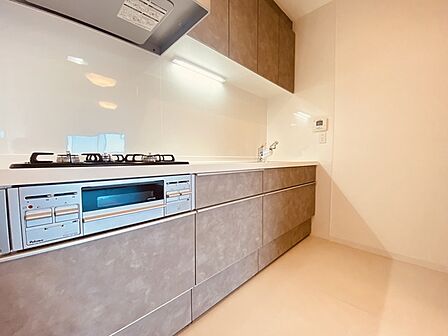 壁付のキッチンは上部に収納が作りやすいのがメリット。空間を有効活用したすっきりとしたデザイン。 