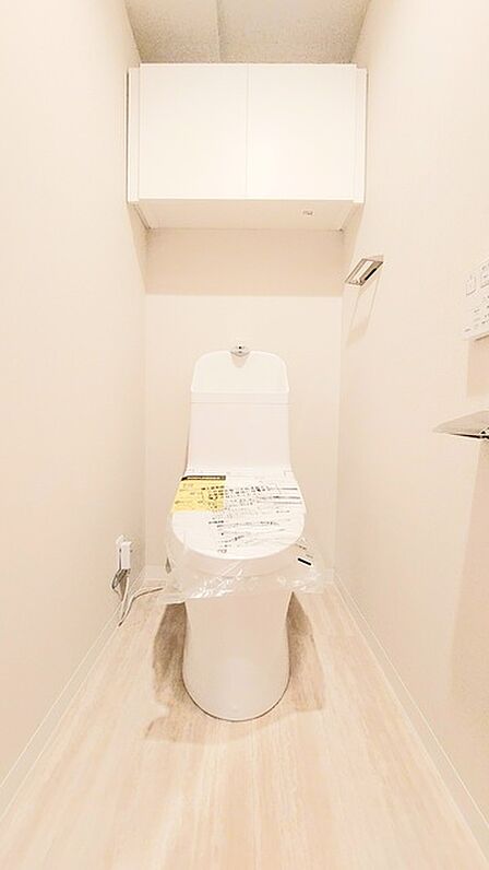 ウォシュレット機能付きのトイレ。収納もあり実用性も兼ね備えた造り。