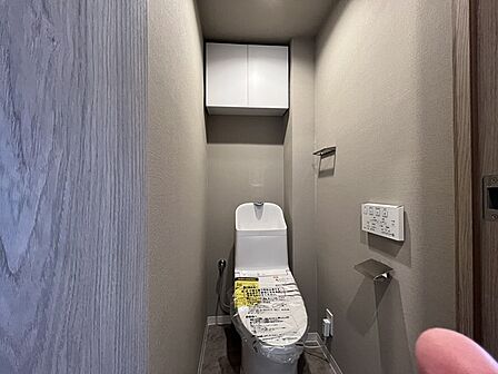 ウォシュレット機能付きのトイレ。収納もあり実用性も兼ね備えた造り。