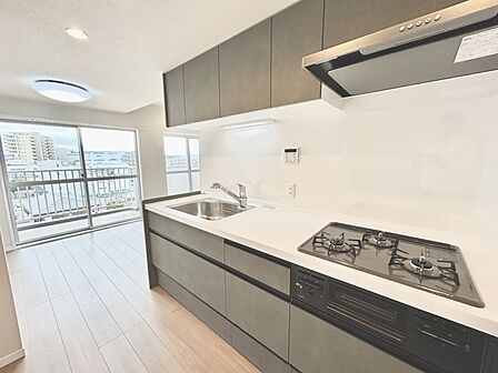 壁付のキッチンは上部に収納が作りやすいのがメリット。空間を有効活用したすっきりとしたデザイン。