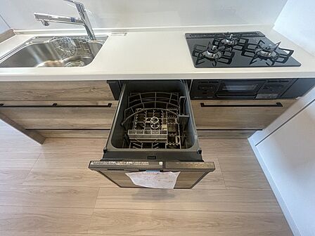 木目の柔らかな質感が落ち着きを添えるキッチンに、食洗機を備えた機能的な設備が調和し、日々の暮らしに心地よいゆとりを生み出します