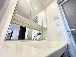 [洗面] 三面鏡タイプのワイドな洗面化粧台を採用し、キャビネット収納はぎっしり色々な物を収納でき下部収納もございます。シャワーヘッドタイプを採用しておりますのでお掃除など楽々できます。