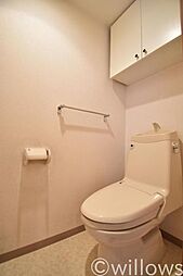 [トイレ] トイレは白を基調とし、清潔感のある空間に。お気に入りの絵画を飾ったり、小さなスペースでも工夫次第で素敵な空間になります。上部の吊戸棚はトイレ用品の収納が可能です。
