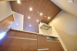 [キッチン] スタイリッシュな色合いにまとめたキッチン。出し入れしやすく使い勝手の良いスライド収納も重宝します。天井に散りばめられた間接照明が、料理の際の手元を明るく照らします。